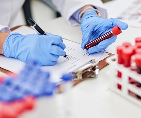 Lab technician recording a blood sample for testing